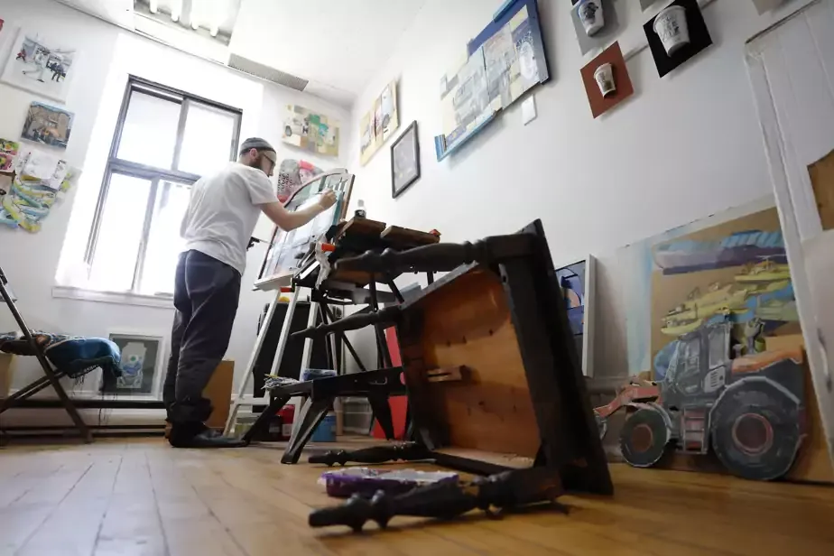 Un artiste peint dans l'atelier de la galerie.