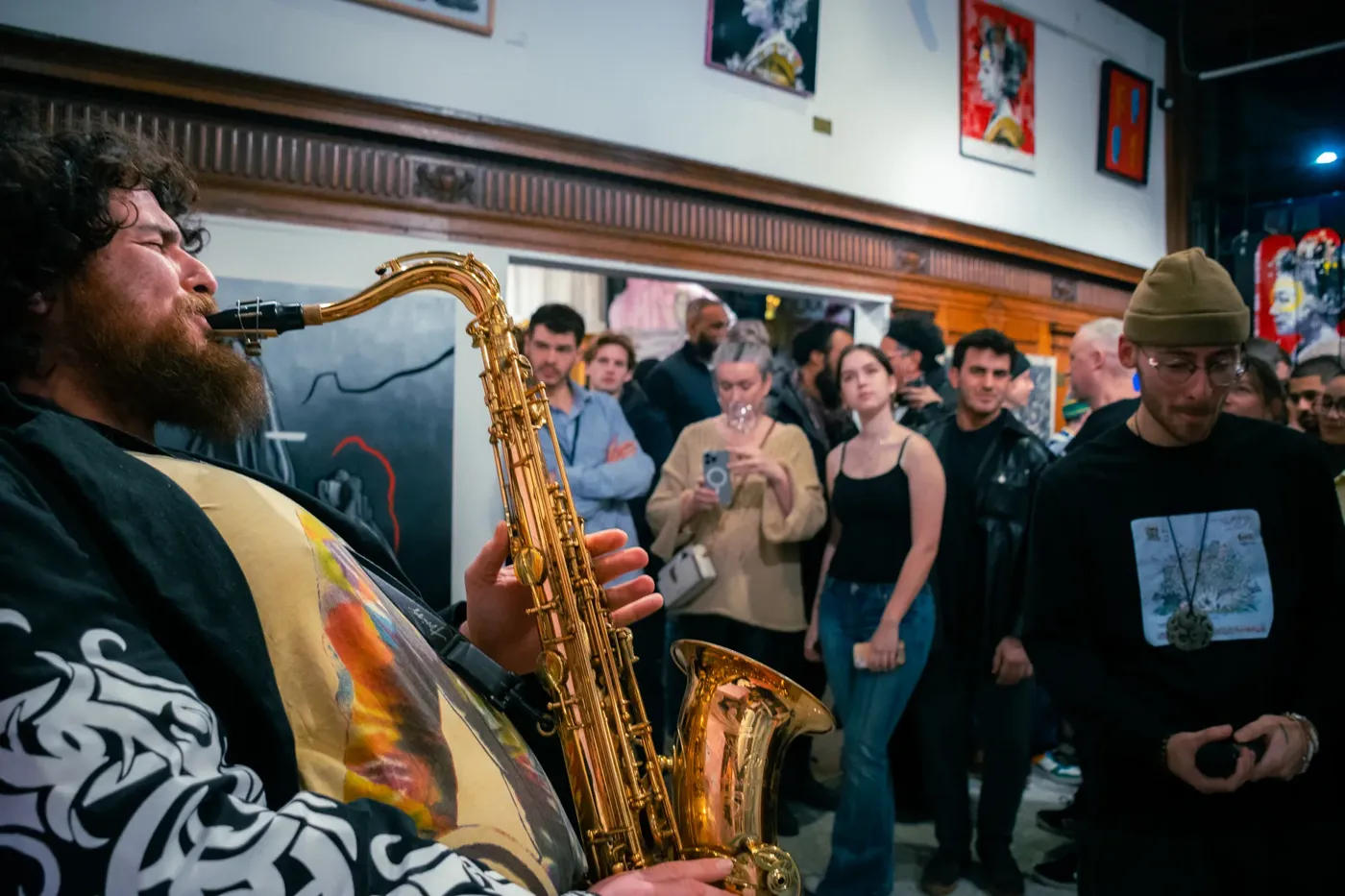 Un saxophoniste joue devant le public dans la galerie.